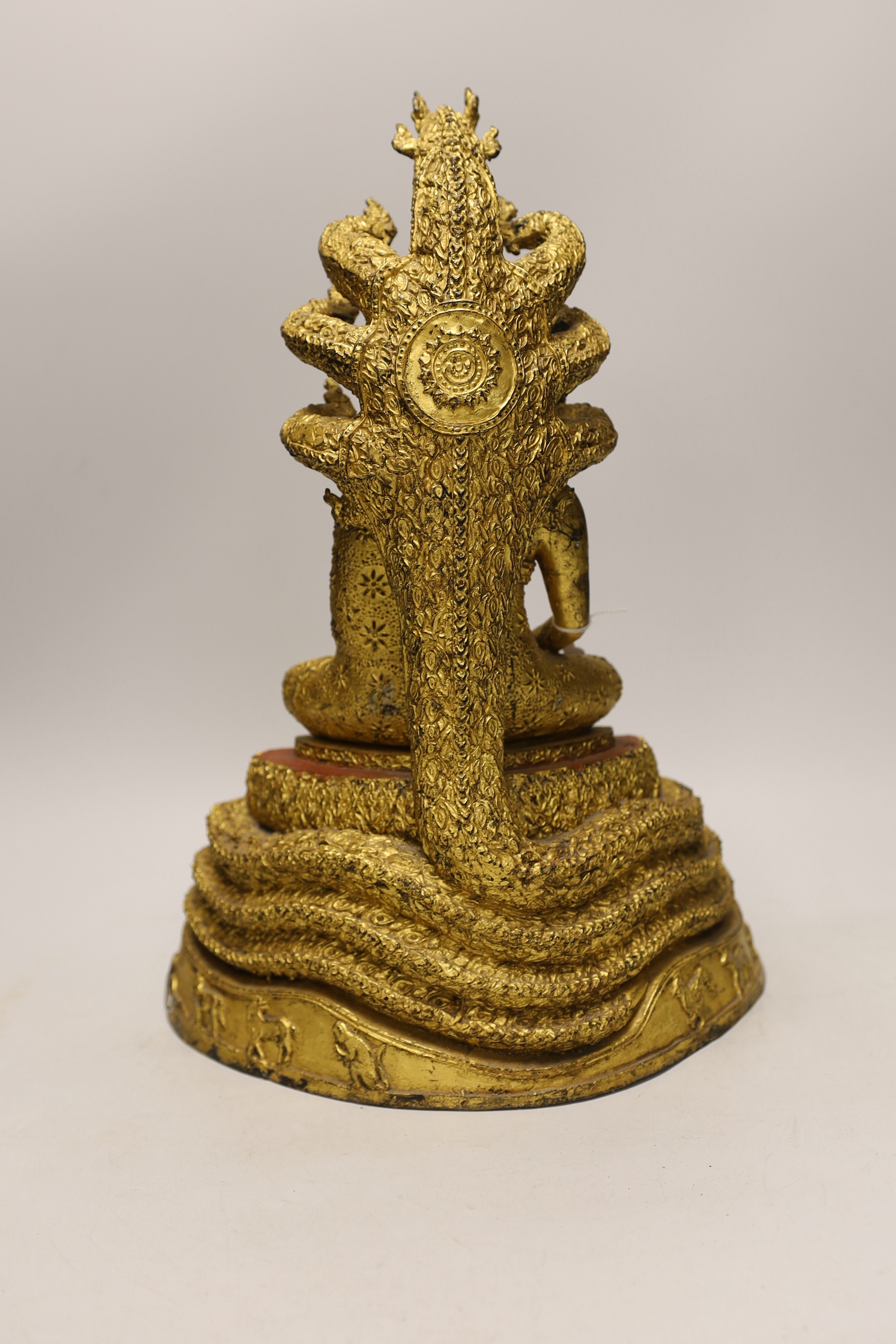 A large Thai gilt bronze seated figure of Buddha on a naga throne, 43cm high